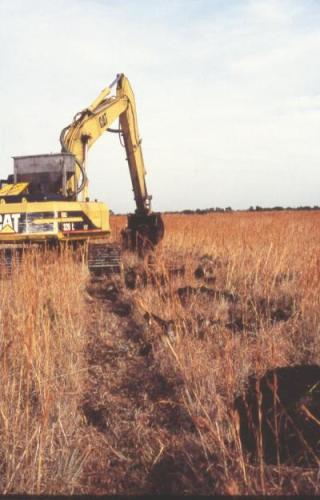 Tracked excavator making mounds